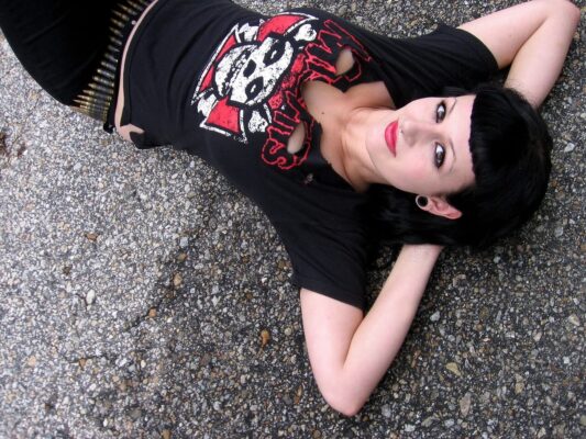 Mujer con estilo gótico usando una playera de Misfits con la calavera Fiend Skull, representando rebeldía y cultura punk.